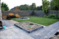 Kindvriendelijke achtertuin met bestrating, gazon en trampoline 1