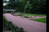 Tuin met groot gazon en oprit van rode betonklinkers