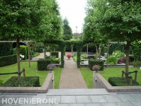 Groene tuin met vijver, pergola en bomen