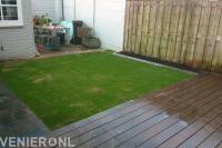 Houten vlonder bij gazon van kunstgras