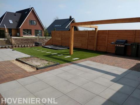 Tuinaanleg met bestrating, kunstgras, houten pergola en schutting 1