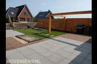 Tuinaanleg met bestrating, kunstgras, houten pergola en schutting 1