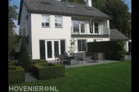 Strakke achtertuin met terras en gazon