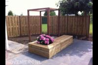 Tuin met bestrating, houten schutting en pergola