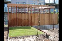 Tuinaanleg met schutting, gazon en keerwand voor hoogteverschillen