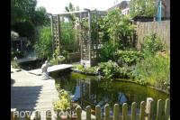 Tuin met vijver en houten vlonder en pergola