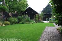 Diepe tuin met strak gazon en buitendouche