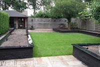 Achtertuin met bestrating, gazon en plantenbakken