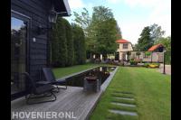 Blokhut met vlonder bij strakke vijver