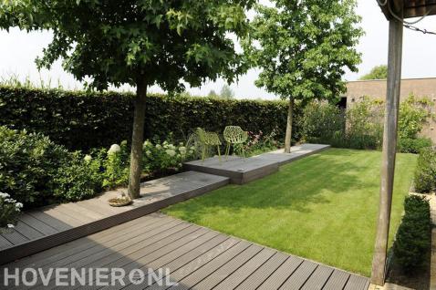 Romantische tuin met gazon, vlonder en veel groen