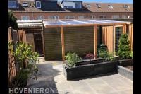 Tuinaanleg met bestrating, plantenbakken en overkapping