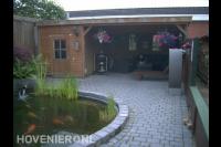 Tuin met vijver en houten overkapping met berging