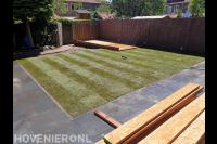 Tuinaanleg met bestrating, gazon van graszoden en houten vlonder