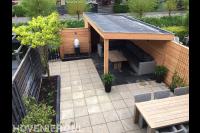 Kleine achtertuin met houten overkapping en schutting