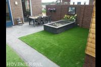 Tuinaanleg met sierbestrating, kunstgras en vijver