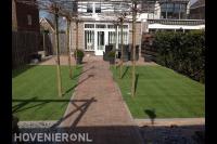 Moderne tuin met kunstgras, cortenstaal plantenbakken en leibomen 3