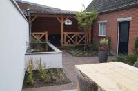 Kleine achtertuin met vijver en houten veranda