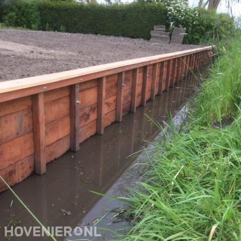 Houten beschoeiing langs het water