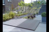 Tuin met hoogteverschil, trap, bestrating en houten vlonder