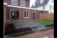 Achtertuin aanleggen met bestrating, gazon en houten vlonder