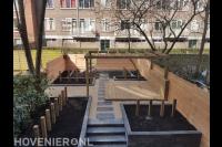 Tuin met bestrating, split en houten vlonder, pergola en schutting 1