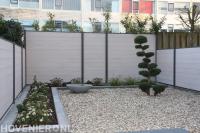 Onderhoudsvriendelijke tuin met grind, plantenbak en schutting