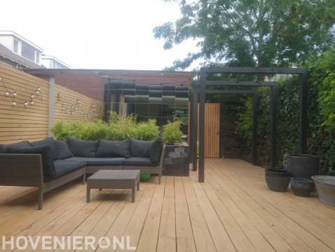 Achtertuin met houten vlonder en pergola