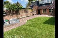 Achtertuin met sierbestrating en grasmatten