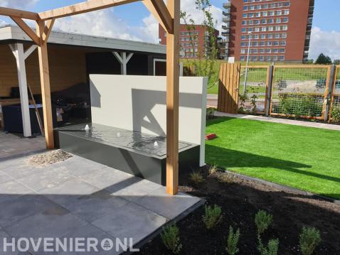 Tuin met kleine vijver, pergola, kunstgras en overkapping