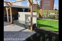 Tuin met kleine vijver, pergola, kunstgras en overkapping