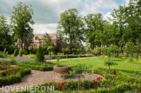 Ruime tuin met groot gazon en veel groen bij kerk