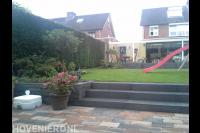 Tuin met gazon en hoogteverschillen verbonden via trappetjes