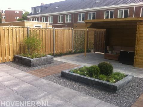 Tuinaanleg met bestrating, houten overkapping en schutting