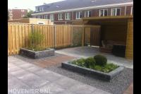 Tuinaanleg met bestrating, houten overkapping en schutting