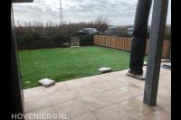 Terras van keramische tegels en gazon van kunstgras