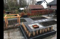 Tuinaanleg met houten pergola, bestrating en plantenbakken