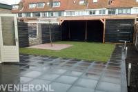 Tuin met betontegels, graszoden en Douglas overkapping met berging
