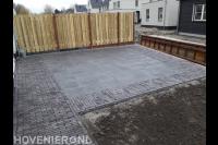 Achtertuin met bestrating en houten schutting