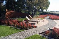 Tuin met kleurrijke beplanting, vlonder en looppad van koppelstenen 1