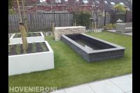 Moderne tuin met gazon, strakke vijver en witte plantenbakken