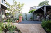 Tuinaanleg met terras, split, beplanting en houten overkapping