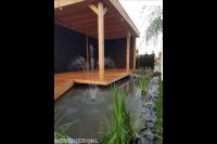 Houten overkapping met vlonder bij vijver met fontein