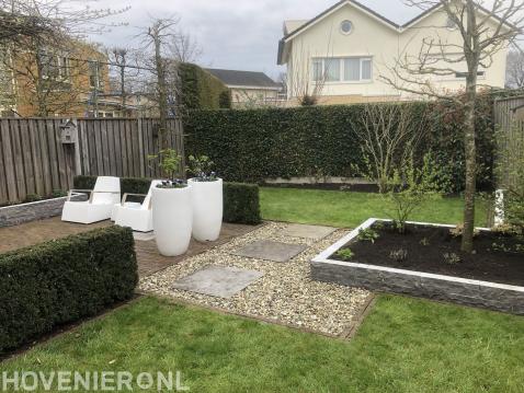 Moderne tuin met verhoogde borders van natuursteen stapelblokkken