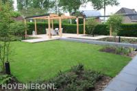 Tuinaanleg met gazon en grote houten pergola