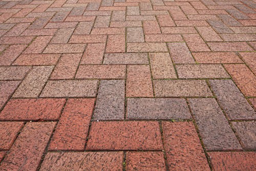 Gekleurde betonklinkers in een elleboogverband